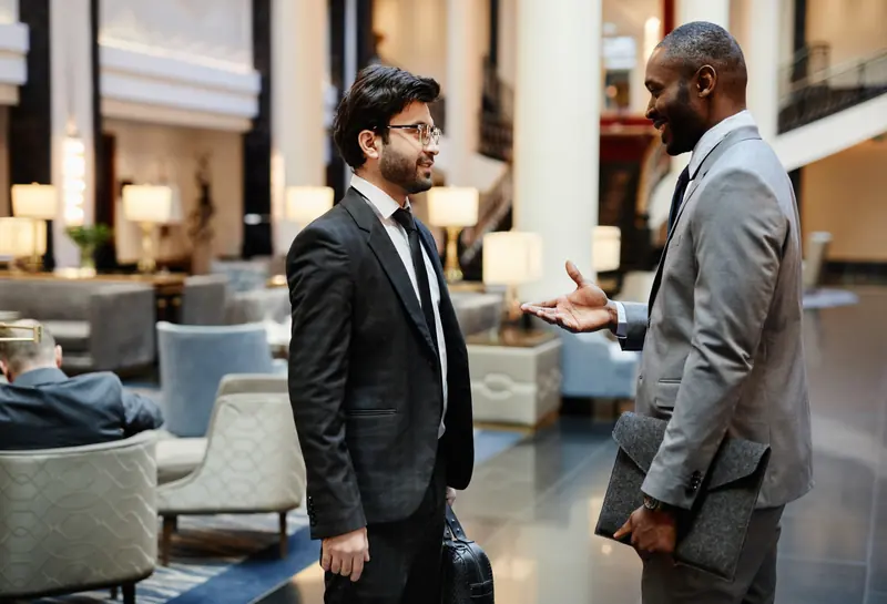 Deux hommes d’affaires en conversation dans le hall d’un hôtel.