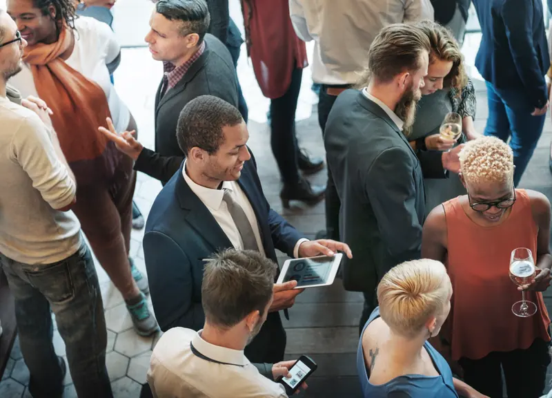 Des invités échangent lors d’une réception professionnelle.
