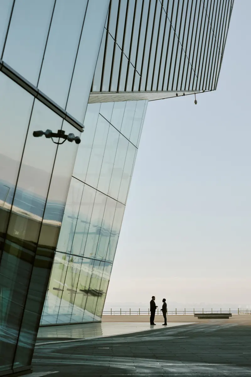 La façade de verre d’un immeuble contemporain contre un ciel clair.